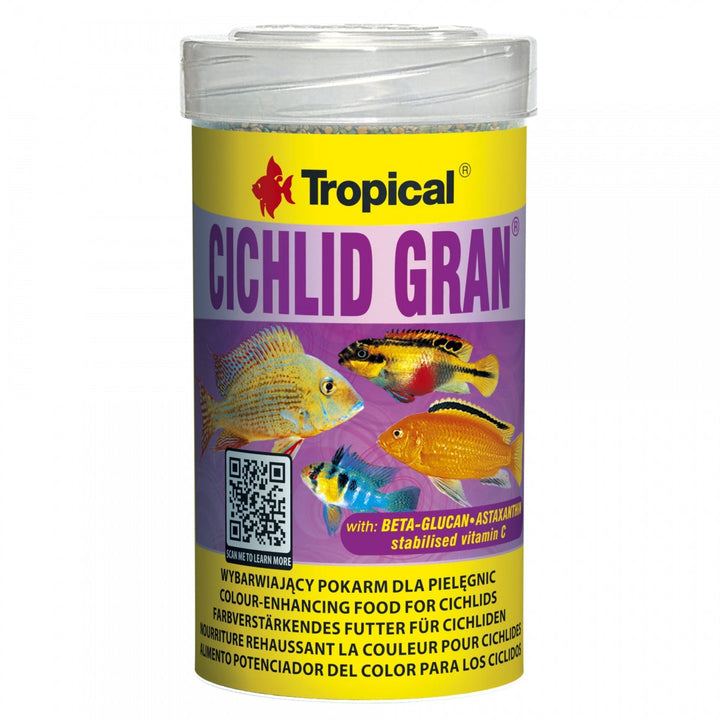 A cylindrical plastic jar of Tropical Cichlid Gran fish food, featuring a yellow and purple label with images of various colorful cichlids and a QR code, set against a plain white background.